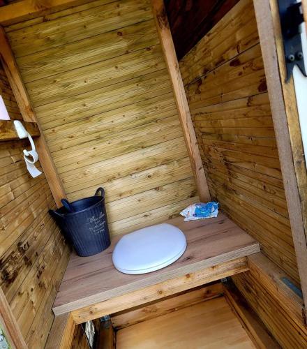 - des toilettes dans un sauna en bois avec un seau dans l'établissement Au bord de l'eau, à La Neuville-aux-Tourneurs
