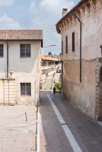 an alley in an old building with a person walking down the street at Naviglio suite apartments in Robecco sul Naviglio