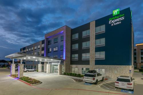 an office building with a car parked in a parking lot at HOLIDAY INN EXPRESS & SUITES DALLAS PLANO NORTH by IHG in Plano