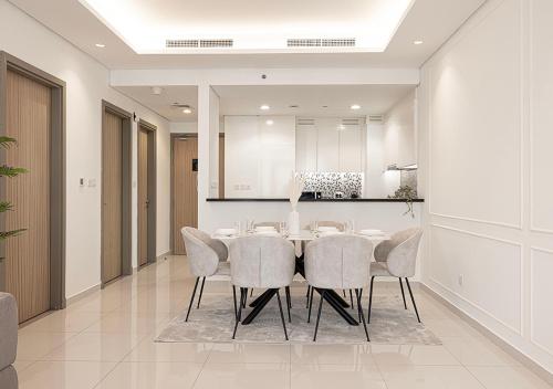 a dining room with a table and chairs at Bright High Floor Apartment in a 5 Star Hotel Resident Tower w Burj View and access to 64th Infinity Pool, Gym, Sauna, Spa, Restaurants, Bars and more in Dubai