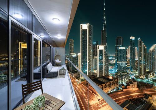 a room with a view of a city at night at Bright High Floor Apartment in a 5 Star Hotel Resident Tower w Burj View and access to 64th Infinity Pool, Gym, Sauna, Spa, Restaurants, Bars and more in Dubai