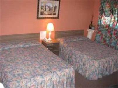 a hotel room with two beds and a lamp on a table at Four Seasons Motel in Catskill