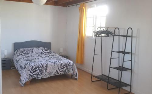 - une chambre avec un lit et une échelle à côté d'une fenêtre dans l'établissement La maisonnette 2personnes le rdc à 1200m de la mer, à Agon-Coutainville