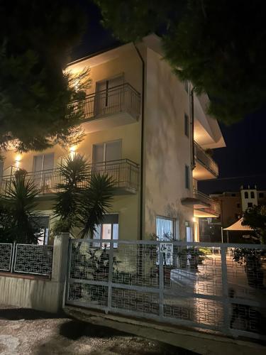 a building with a fence in front of it at night at Pensione Vagnozzi in Grottammare