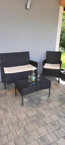 two chairs and a coffee table on a patio at Domki letniskowe nad Jeziorem Solińskim Pasiekówka in Zawóz