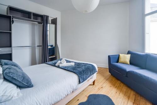 une chambre avec un lit et un canapé bleu dans l'établissement Le Paradis D'Oé - Hypercentre - Netflix, à Tours