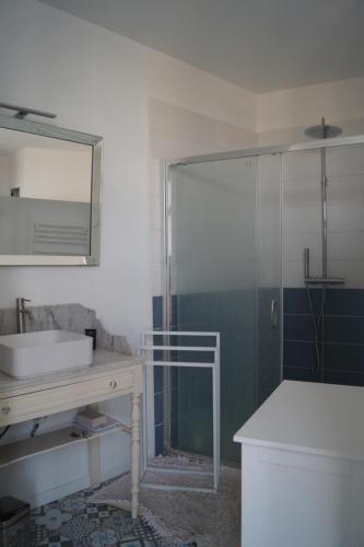 une salle de bain avec une douche, un lavabo et un miroir dans l'établissement L'océane, à Châtelaillon-Plage