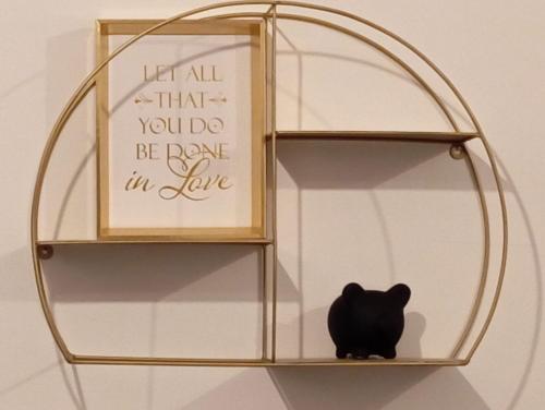 a black cat sitting on a shelf with a sign at Black Diamond Lux - deluxe riverside apartment in Senta