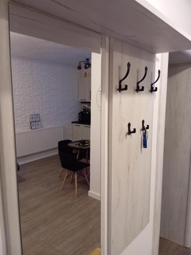 a door in a room with a kitchen and a table at Black Diamond Lux - deluxe riverside apartment in Senta