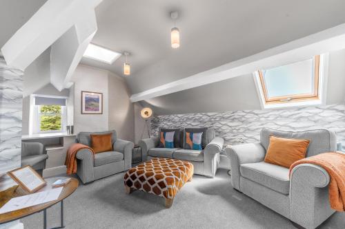 a living room with couches and chairs in a room at Fell215 - Classic loft apartment at The Lairbeck in Keswick in Keswick