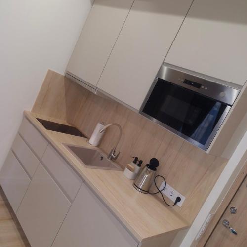a kitchen counter with a sink and a microwave at M&M Apartamentai in Klaipėda