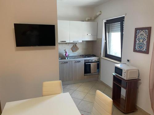 a small kitchen with a microwave and a stove at casa vacanza Cavour in Avezzano