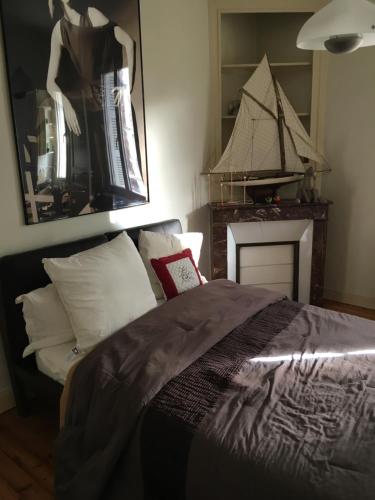 a bedroom with a bed and a boat on the wall at MAISON DE VILLE Deauville in Deauville