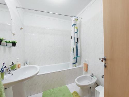 a bathroom with a sink and a toilet and a bath tub at GreenSea II in Peniche