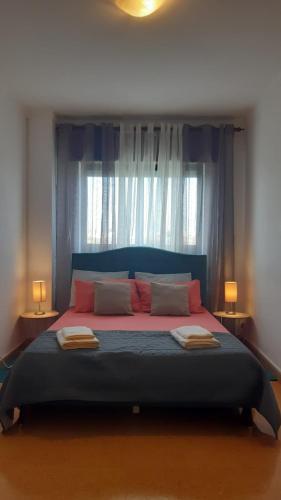 a large bed in a bedroom with a window at GreenSea II in Peniche