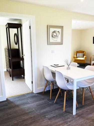a dining room with a white table and chairs at Larks Leaze Lodge, Steeple Ashton, Wiltshire in Trowbridge