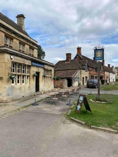 a group of buildings with tables and a sign at Larks Leaze Lodge, Steeple Ashton, Wiltshire in Trowbridge