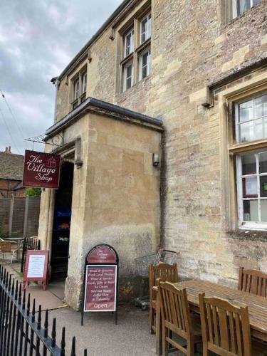 a building with a table and chairs in front of it at Larks Leaze Lodge, Steeple Ashton, Wiltshire in Trowbridge