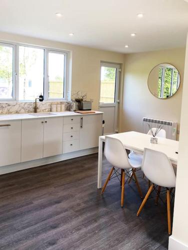 a kitchen with a table and chairs and a sink at Larks Leaze Lodge, Steeple Ashton, Wiltshire in Trowbridge