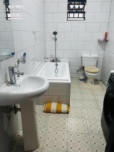 a bathroom with a sink and a tub and a toilet at Spacious and comfortable House in Kampala Uganda in Kasiyirize