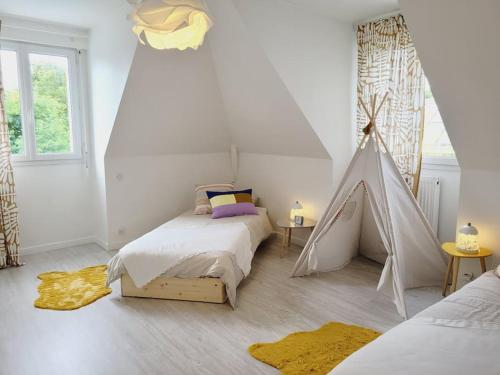 een slaapkamer met 2 bedden en een speeltent bij La villa des Taillis, 10 pers in La Chapelle-sur-Erdre