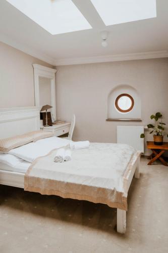 a white bedroom with a bed and a skylight at Hotel Adler in Byczyna