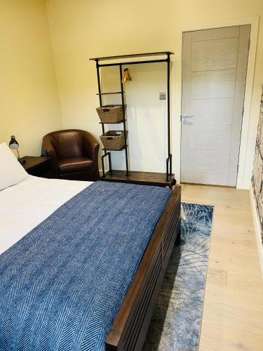 a bedroom with a bed and a chair at Bow Lake Equestrian in Eastleigh