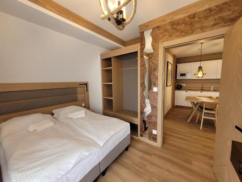 a bedroom with a bed and a dining room at Apartament z prywatną sauną i widokiem na Tatry SKIBUS Kulkolandia Sala Zabaw Balia in Białka Tatrzanska