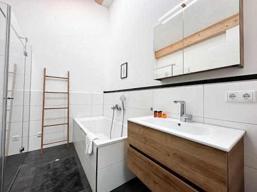 a bathroom with a sink and a bath tub at Staufner Maisonette in Oberstaufen
