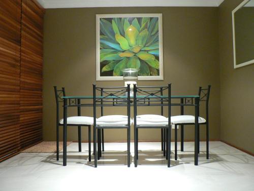 a dining room table with chairs and a painting at Waterfront Jervis Bay Escape Cooinda in Sanctuary Point