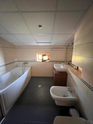 a bathroom with a tub and a toilet and a sink at Family Hotel Casa del Mare in Sozopol