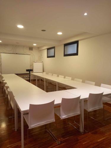 a conference room with white tables and white chairs at EXE Wellington in Figueira da Foz
