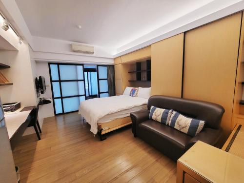 a bedroom with a bed and a couch in it at Yuanben Mountain Hot Spring Homestay in Jiaoxi