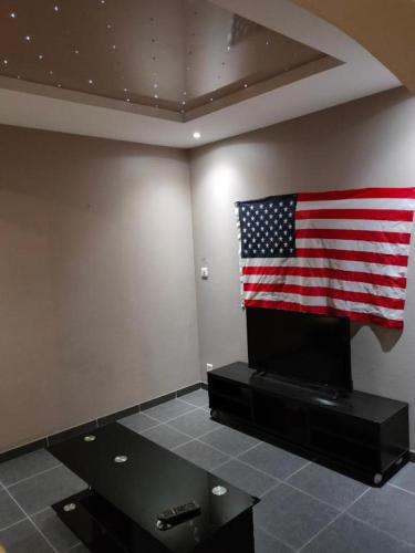 Chambre avec drapeau américain sur le mur dans l'établissement Le T3 de Julien, à Tarbes
