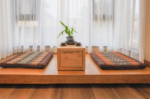 two cushions on a wooden bench with a potted plant at Xishuangbanna Sadu Lanmei Resort Hotel in Jinghong