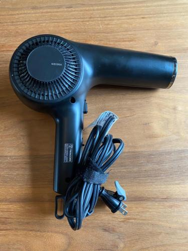 a black blow dryer on a wooden table with a tool at 瀬戸内ハウス 疲れを癒す木のお家 バス停より徒歩3分 Free WIFI 無料駐車場 in Sakaide