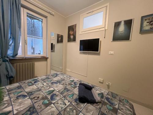 a bedroom with a bed and a tv on the wall at La Perla di Ponente in Ospedaletti