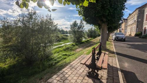 un banc assis sur un trottoir à côté d'un arbre dans l'établissement le gîte de la ruelle, à Neuvy-sur-Loire