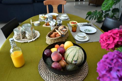 - une table avec un bol de fruits et de légumes dans l'établissement Au Milieu des Haras, à Saint-Pierre-Azif