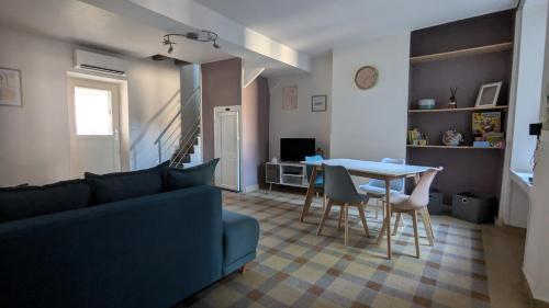 un salon avec un canapé bleu et une table dans l'établissement le gîte de la ruelle, à Neuvy-sur-Loire