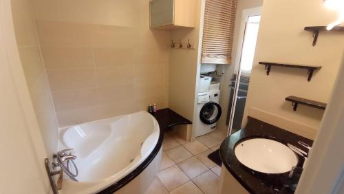 La salle de bains est pourvue d'une baignoire, d'un lavabo et d'un lave-linge. dans l'établissement Bas de Villa 