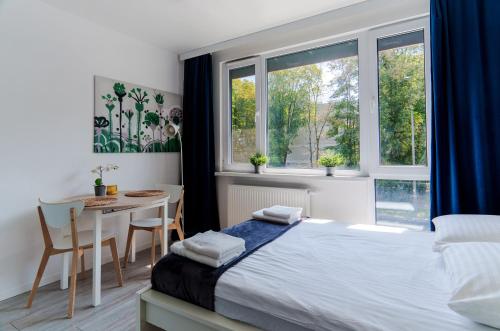 a bedroom with a bed and a table and a window at The Park Suites in Warsaw
