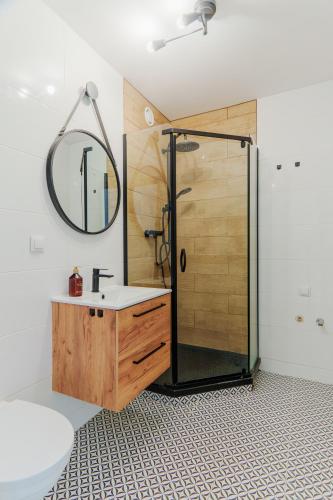 a bathroom with a shower and a sink and a mirror at The Park Suites in Warsaw