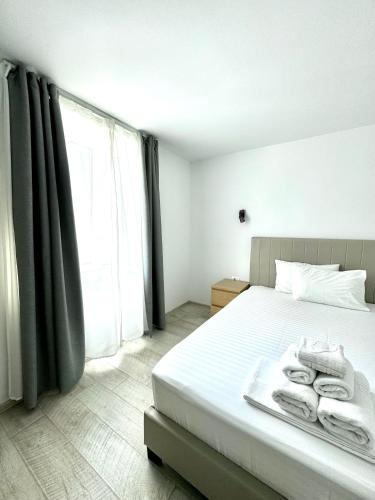 a bedroom with a bed with towels on it at Vila Eric in Eforie Sud