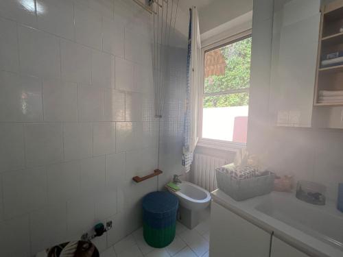 a bathroom with a toilet and a sink and a window at La Perla di Ponente in Ospedaletti