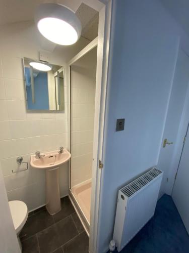 a bathroom with a sink and a toilet and a mirror at The New ATLAS HOTEL in Blackpool