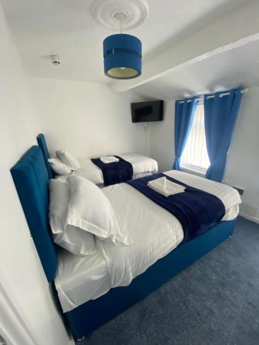 a bedroom with two beds with blue and white at The New ATLAS HOTEL in Blackpool