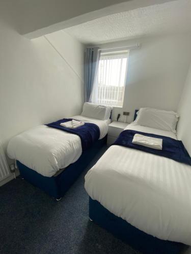 a room with two beds and a window at The New ATLAS HOTEL in Blackpool