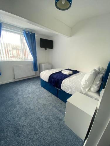 a bedroom with a bed and a tv and a window at The New ATLAS HOTEL in Blackpool