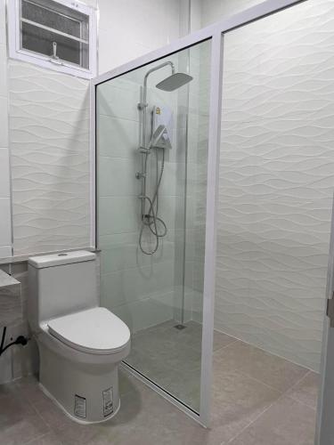 a bathroom with a toilet and a glass shower at Black and Yellow Hostel in Ban Thab Mak